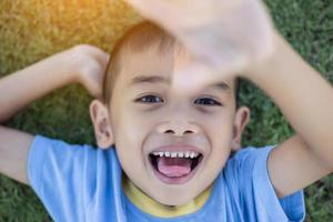 Happy mulatto boy child is smiling enjoying adopted life. Portrait of young boy in nature, park or outdoors. Concept of happy family or successful adoption or parenting. photo