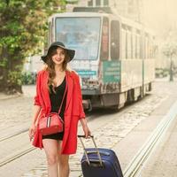 Beautiful young girl walking with blue suitcase. photo