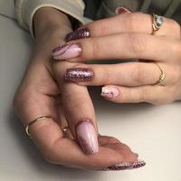 Stylish trendy female pink manicure with design.Hands of a woman with pink manicure on nails photo