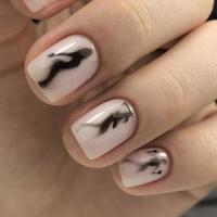 Stylish trendy female white manicure with design.Hands of a woman with white manicure on nails photo