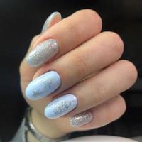 manicura creativa de año nuevo. manicura de nieve en esmalte de uñas de color con copos de nieve plateados foto