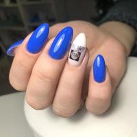 elegante manicura femenina azul de moda. manos de una mujer con manicura azul en las uñas foto