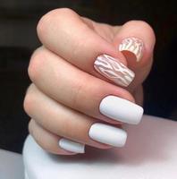 Stylish trendy female white manicure with design.Hands of a woman with white manicure on nails photo