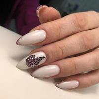 The hand of a young woman with a white manicure and design for the New Year and Christmas. photo