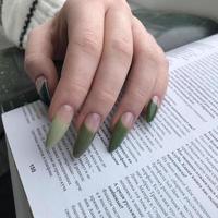 elegante manicura femenina verde de moda. manos de una mujer con manicura verde en las uñas foto