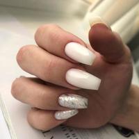 elegante manicura femenina blanca de moda. manos de una mujer con manicura blanca en las uñas foto