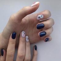 Stylish trendy female blue manicure with design.Hands of a woman with blue manicure on nails photo