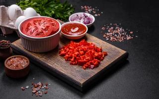 Ingredients for making shakshuka, dishes with fried eggs with tomato sauce, spices and herbs photo