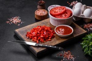Ingredients for making shakshuka, dishes with fried eggs with tomato sauce, spices and herbs photo