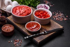Ingredients for making shakshuka, dishes with fried eggs with tomato sauce, spices and herbs photo