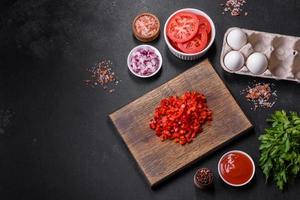 Ingredients for making shakshuka, dishes with fried eggs with tomato sauce, spices and herbs photo