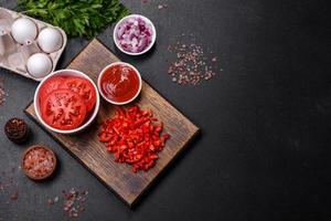 Ingredients for making shakshuka, dishes with fried eggs with tomato sauce, spices and herbs photo