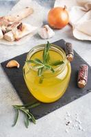 Homemade beef bone and vegetable broth with turmeric seasoning in a glass jar for storage and carrying. Healthy food with collagen and amino acids. Copy space. photo