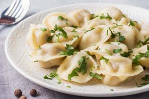 Traditional pelmeni, ravioli, dumplings filled with meat on plate, russian kitchen photo