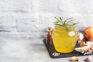 Homemade beef bone and vegetable broth with turmeric seasoning in a glass jar for storage and carrying. Healthy food with collagen and amino acids. Copy space. photo