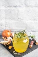 Homemade beef bone and vegetable broth with turmeric seasoning in a glass jar for storage and carrying. Healthy food with collagen and amino acids. Copy space. photo