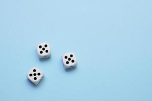 three dice with the same dropped out numbers lie on a blue background photo