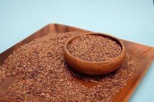 Flax seeds in a wooden bowl on a blue background,healthy food concept photo