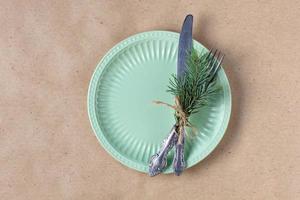 Holiday table setting with branch of christmas tree, empty plate and decorations. New year flat lay food concept photo