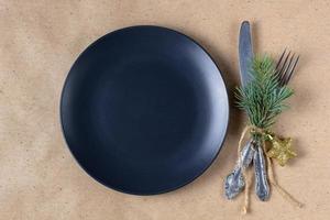 Holiday table setting with branch of christmas tree, empty plate and decorations. New year flat lay food concept photo