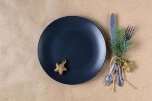 Holiday table setting with branch of christmas tree, empty plate and decorations. New year flat lay food concept photo