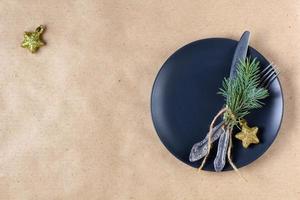 Holiday table setting with branch of christmas tree, empty plate and decorations. New year flat lay food concept photo