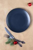 Holiday table setting with branch of christmas tree, empty plate and decorations. New year flat lay food concept photo