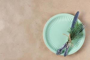 Holiday table setting with branch of christmas tree, empty plate and decorations. New year flat lay food concept photo