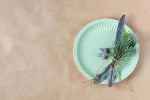 Holiday table setting with branch of christmas tree, empty plate and decorations. New year flat lay food concept photo