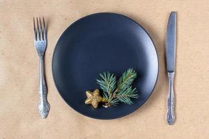 Holiday table setting with branch of christmas tree, empty plate and decorations. New year flat lay food concept photo