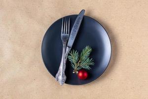 Holiday table setting with branch of christmas tree, empty plate and decorations. New year flat lay food concept photo