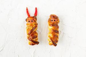 Scary sausage mummies in dough for kids party. Funny crazy Halloween food for children. photo