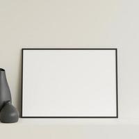 Minimalist front view horizontal black photo or poster frame mockup leaning against wall on table with vase. 3d rendering.