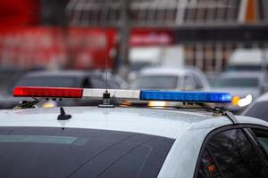 police car lights in city street at winter day with cars traffic in blurry background photo