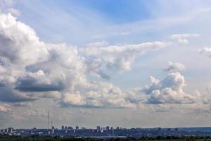 russian summer daylight cityscape with large cumulus clouds and tiny horizon line of the panel condominium houses photo