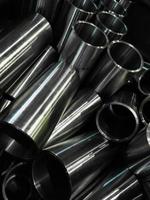 dark industrial background with cnc machined shiny steel pipes - selective focus and lens blur tech photo