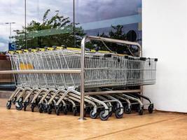 grocery carts standing in front of a supermarket glass showcase photo