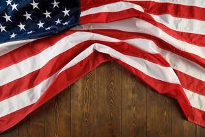 crumpled usa flag on flat textured wooden surface background photo