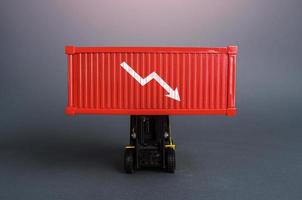 Red shipping container with down arrow. Decrease in imports and exports of goods. Trade traffic decreasing. Production fall. Lowering transportation prices. Decline in profits. Low shipping rates. photo