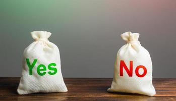 Two bags with Yes and No. Risk planning. Advantages and disadvantages. Useful and harmful properties. Decision making, evaluating profit and consequences. Choice between positive and negative answer. photo