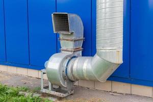 industrial grade air extraction duct with electrical motor on blue wall photo