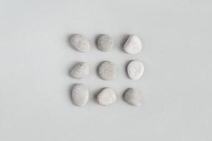 Pebble stones on light gray background, minimal design flat lay photo
