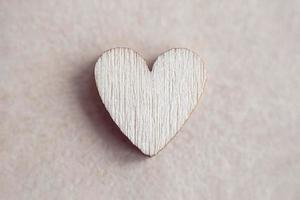 Wooden heart on paper background, love concept, minimalist Valentines day design photo