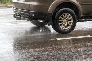 gray suv rushes on wet autumnal asphalt road photo