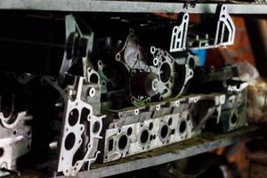 old dirty metal engine parts on dark garage shelf photo