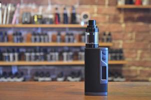 Electronic cigarette on a background of vape shop. E-cigarette for vaping. photo