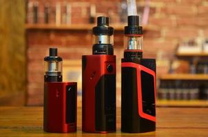 Electronic cigarette on a background of vape shop. E-cigarette for vaping. photo