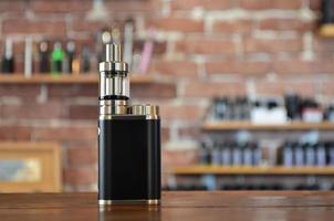 Electronic cigarette on a background of vape shop. E-cigarette for vaping. photo