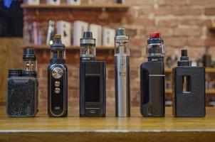 Electronic cigarette on a background of vape shop. E-cigarette for vaping. photo