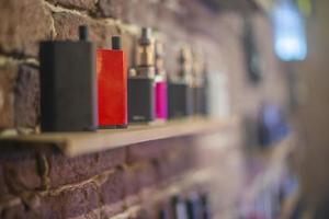 Electronic cigarette on a background of vape shop. E-cigarette for vaping. photo